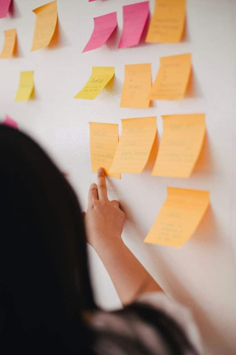 Eine Person zeigt auf eine Pinnwand mit mehreren farbigen Post-it-Notizen. Das Bild symbolisiert die Nachhaltigkeitsoptimierung durch strukturierte Planung und Ideensammlung am Institut für nachhaltige Wassersysteme der Hochschule Hof (inwa).